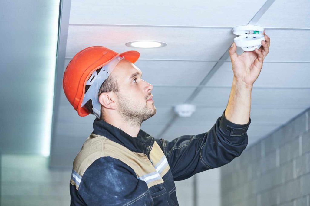 Electrician working on fire alarm system